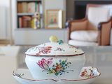 a bowl and saucer sitting on a table in a living room