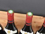 several bottles of wine are lined up in a wooden holder