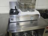 une grande friteuse posée sur un plan de travail dans une cuisine