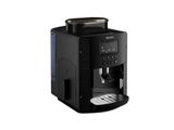 La machine à café est noire et il y a une tasse de café dessus.