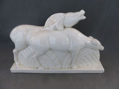 une sculpture blanche représentant un cheval et un chien, posée sur une table