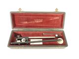 a metal tool in a red case on a white surface