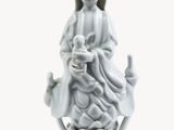 a white figurine of a woman holding a baby