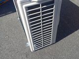 a white air conditioner sitting on the ground next to boxes