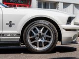 a white mustang parked in front of a building