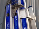 a stack of blue and silver luggage sitting on top of a metal cart