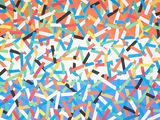 colorful confetti sprinkles are scattered on a white surface