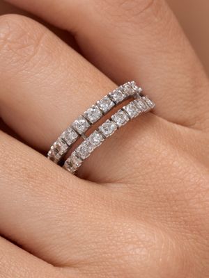 un gros plan sur la main d'une femme portant une bague en diamant au doigt