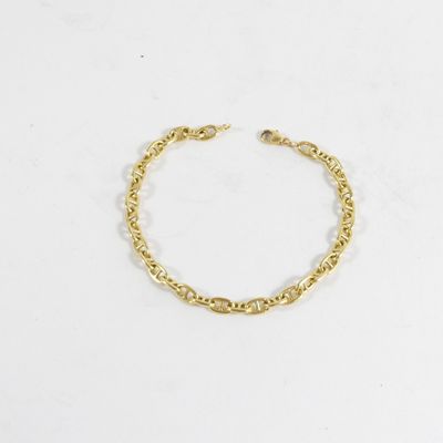 un bracelet en chaîne dorée orné d'une petite perle sur fond blanc
