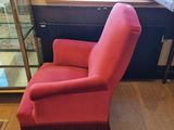 a red chair that is sitting in front of a window