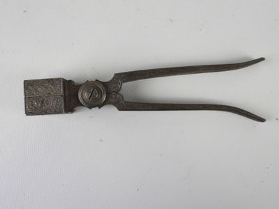 an old pair of tonges sitting on top of a white surface