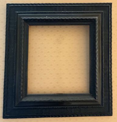 a black picture frame hanging on a wall next to a white wall