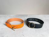a pair of black and orange leather belts with a gold buckle