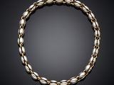 a gold and silver bracelet on a black background