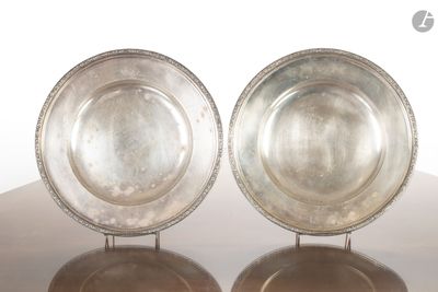 une paire de plats en argent plaqué posés sur un support, sur une table, sur fond blanc