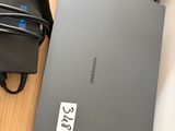 un ordinateur portable posé sur un bureau à côté d'un sac