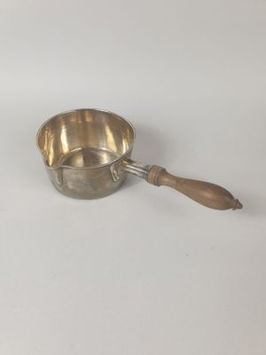 casserole plaquée argent avec un manche en bois sur fond blanc