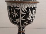 black and white ceramic urn with gold accents on a white table