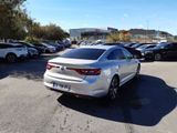 the rear end of a white car parked in a parking lot
