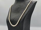 a close up of a mannequin with pearls on it