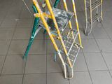 three ladders that are sitting on a tiled floor