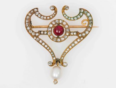 Broche volute en or sertie de diamants centrée d'un cabochon…