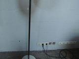 a lamp that is on a stand in the corner of a room