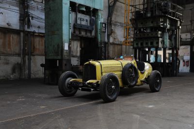 a yellow car parked inside of a building in a factory