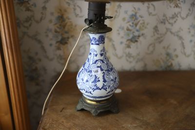 un vase bleu et blanc posé sur une table sur laquelle se trouve une lampe