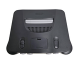 a black game console sitting on top of a white surface