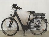 un vélo noir garé contre un mur blanc