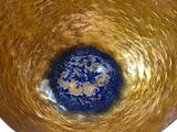 a gold vase with a blue center on a white background
