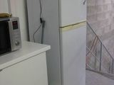 a refrigerator and a microwave in a room with a fish tank on top of it