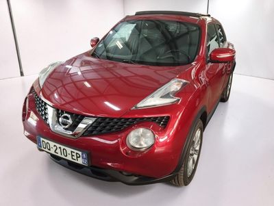a red nissan juke parked in a white room