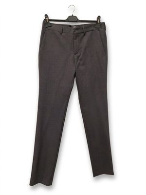un gros plan sur le pantalon d'une personne suspendu à un cintre