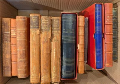 de nombreux livres anciens dans une boîte posée sur une étagère