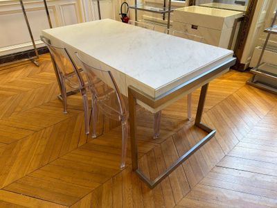 une table blanche avec quatre chaises au milieu de la pièce