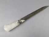 a knife that is sitting on a white surface
