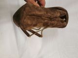 someone is holding a brown purse with a chain around it