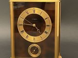 a gold clock with roman numerals on the face