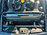 le moteur d'une voiture bleue, le capot ouvert, avec un radiateur