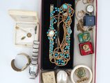 une boîte remplie de bijoux, notamment une montre, des bracelets, des bagues et d'autres objets