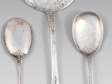 trois cuillères en argent et deux cuillères en argent sur une table
