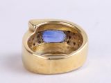 an image of a gold ring with a blue stone inside of it