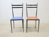 two black and blue chairs with leather seats in front of a white wall