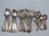beaucoup de cuillères en argent et de cuillères à soupe sur une table