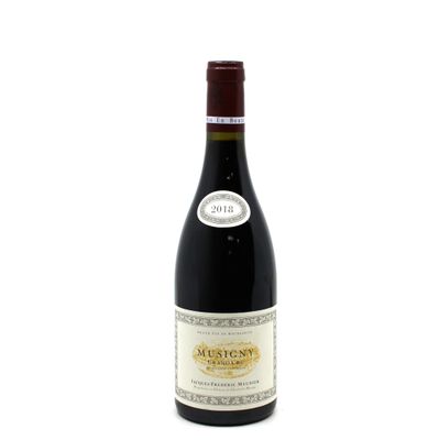 the bottle of red wine is sitting on a white surface