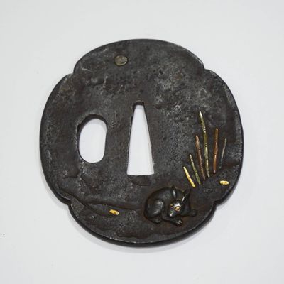 une tsuba en fer noir ornée de fleurs