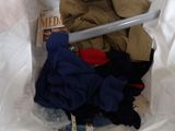 a pile of clothes in a plastic bag on a bed