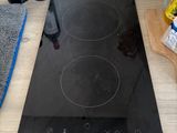 a black stove top on a wooden table with a bottle of wine on it